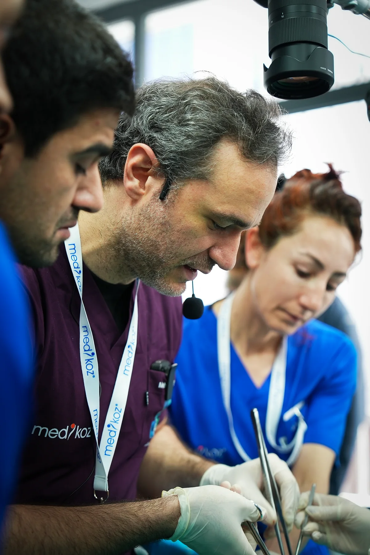 Both hosts and a surgical nurse dissecting at the cadaver station